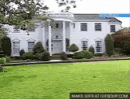 a large white house with a lawn in front of it