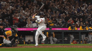 a baseball player swings his bat at a pitch in front of a crowd that is sponsored by t mobile
