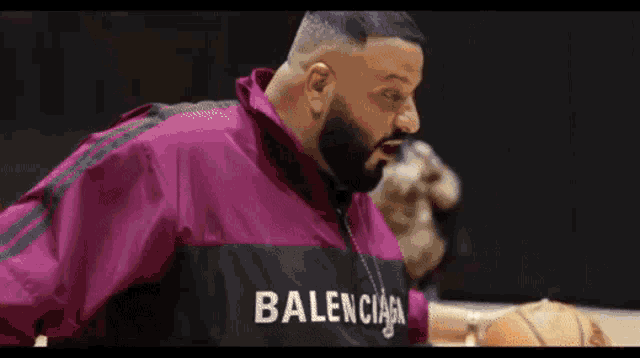 a man with a beard is holding a basketball in his hand .