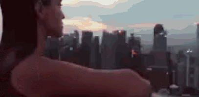 a woman is standing in front of a city skyline with her arms outstretched .