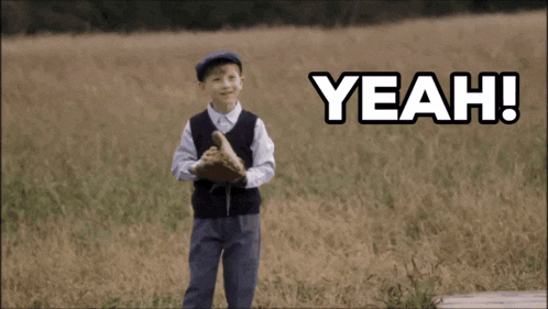 a young boy holding a baseball in a field with the words yeah written above him