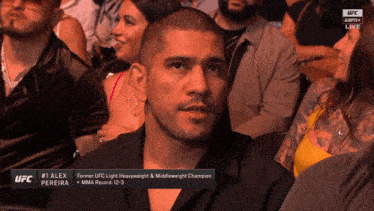 a man in a black shirt is sitting in a ufc audience