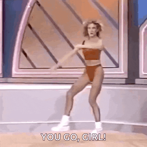 a woman in a bikini is dancing on a stage with the words `` you go , girl '' .