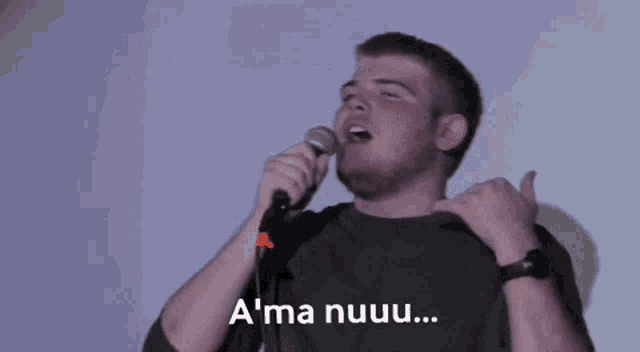 a man singing into a microphone with the words " a ma nuuuu " on the bottom