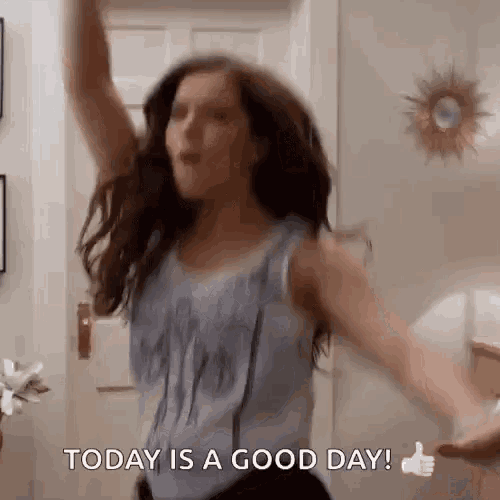 a woman is dancing with her arms in the air and giving a thumbs up sign .