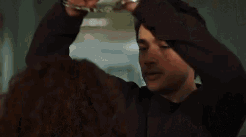 a man is holding a woman 's hair and covering his face .