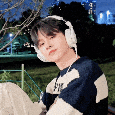 a young man wearing headphones and a sweater with the letter p on it