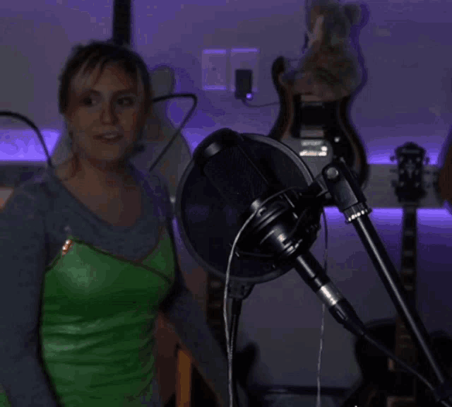 a microphone is sitting in front of a purple wall with guitars hanging on it