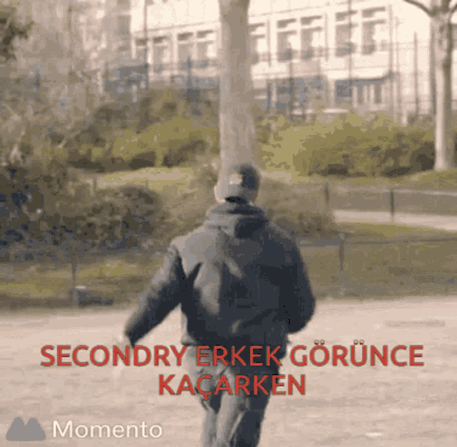 a man is walking in a park with the words secondary erkek gorunce kacarken