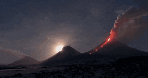 a volcano is erupting at night and the sun is shining brightly behind it