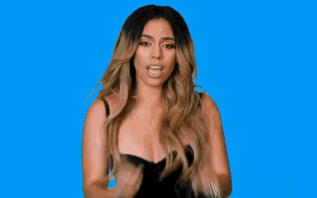 a woman in a black dress is holding her hair in front of a blue background