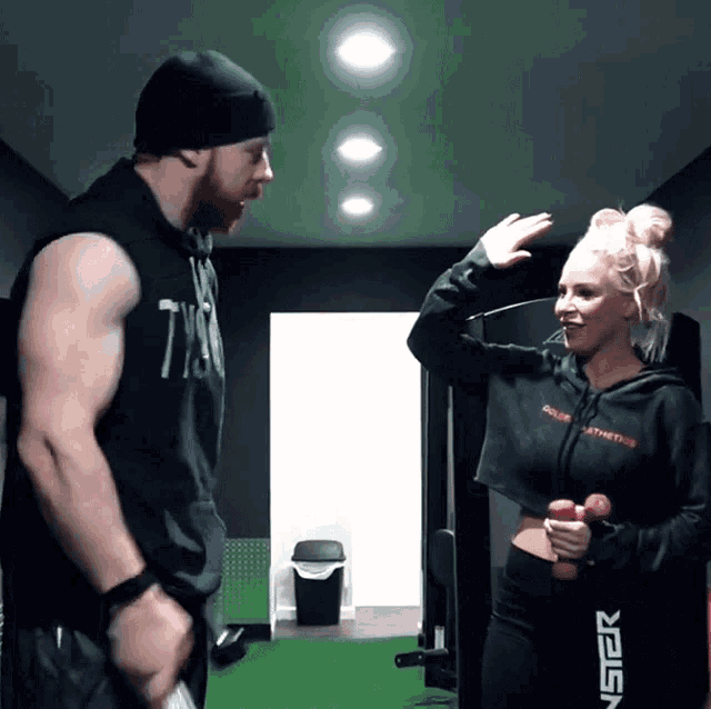 a man and a woman are standing in a hallway and the woman is wearing a black sweatshirt that says nspr
