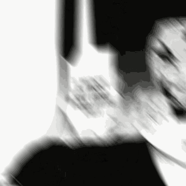 a blurry black and white photo of a person talking on a cell phone