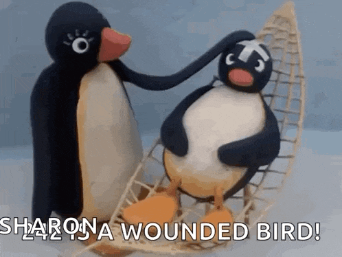two stuffed penguins are sitting in a canoe and one of them is petting the other 's head .