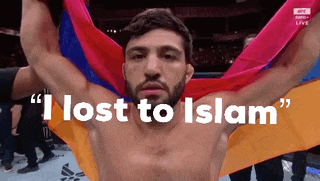 a shirtless man is holding a colorful flag with the words " i lost to islam " written above him