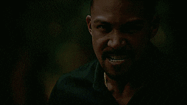 a man with vampire teeth is screaming with his mouth wide open