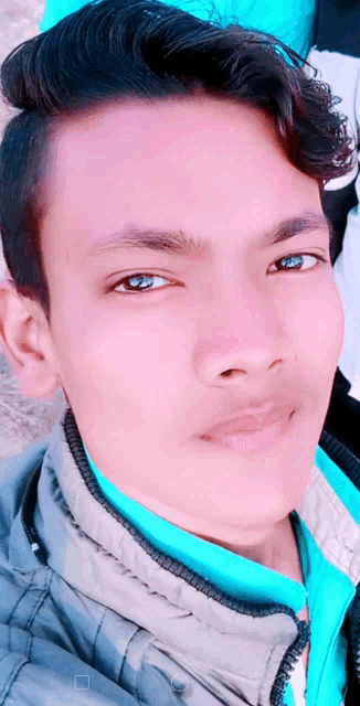 a close up of a man 's face with a blue shirt on
