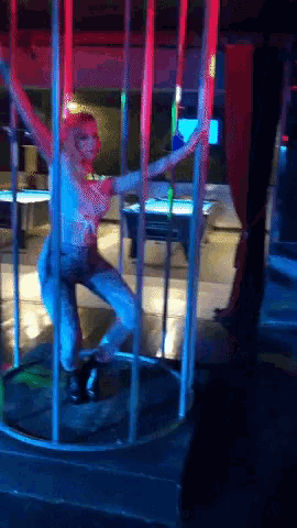 a woman is dancing on a pole in a dark room