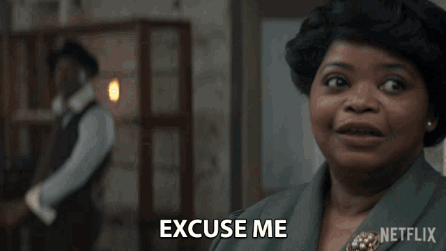 a woman says excuse me in front of a man in a suit