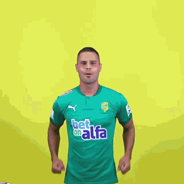 a man wearing a green shirt that says bet on alfa on it