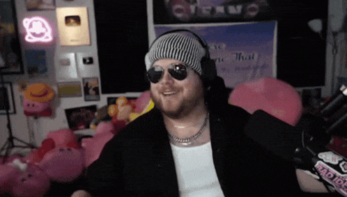 a man wearing sunglasses and headphones is standing in front of a sign that says " eric that "