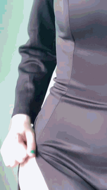 a woman in a black dress has her hand on her hips
