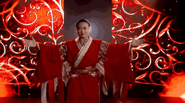 a woman in a red and gold kimono stands in front of a red background