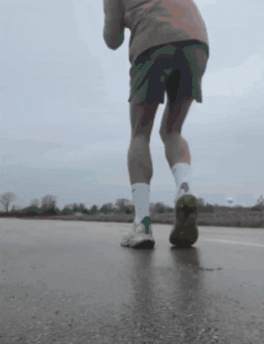 a person is running on a road wearing nike socks