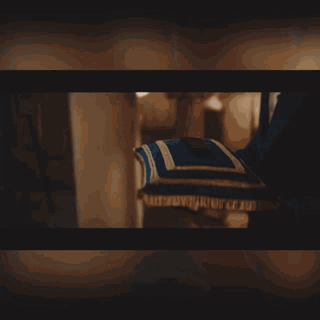 a close up of a person holding a blue and white striped pillow