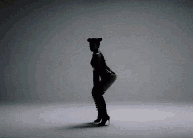 a woman in a black bodysuit and boots is dancing