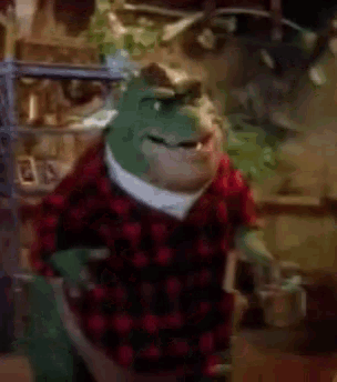 a dinosaur wearing a plaid shirt is standing in a kitchen