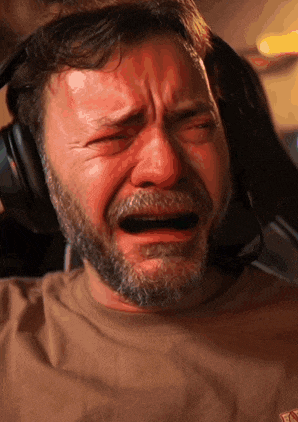 a man with a beard and headphones is crying with his mouth open