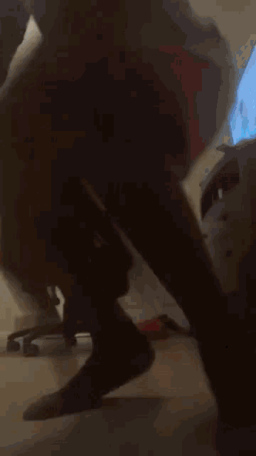 a man in red shorts is standing on a chair in a room