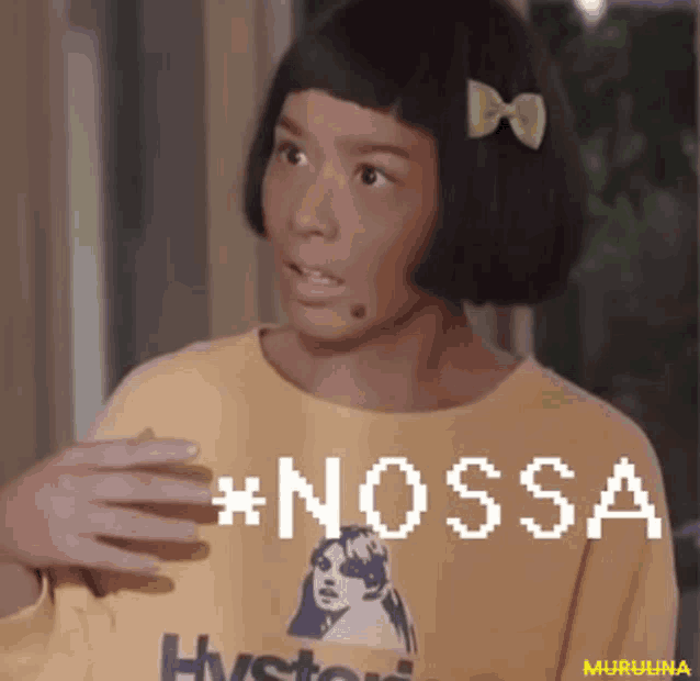 a girl with a bow in her hair is wearing a yellow sweater that says nossa