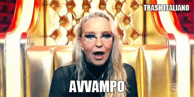 a woman wearing glasses is sitting in a chair with her mouth open and the words avvampo written on the bottom .