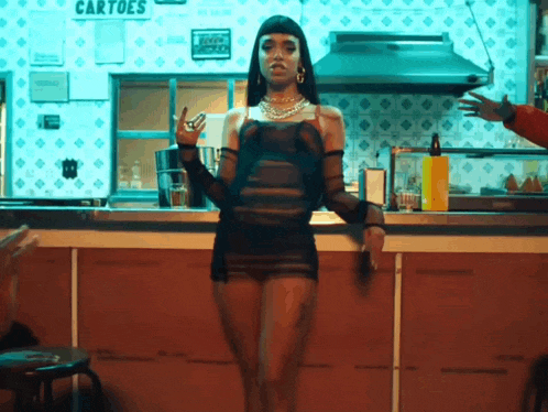 a woman in a black dress is standing in front of a counter with a sign that says cartoes on it .