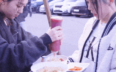 a woman wearing a calvin klein shirt pours ketchup into a bowl of food