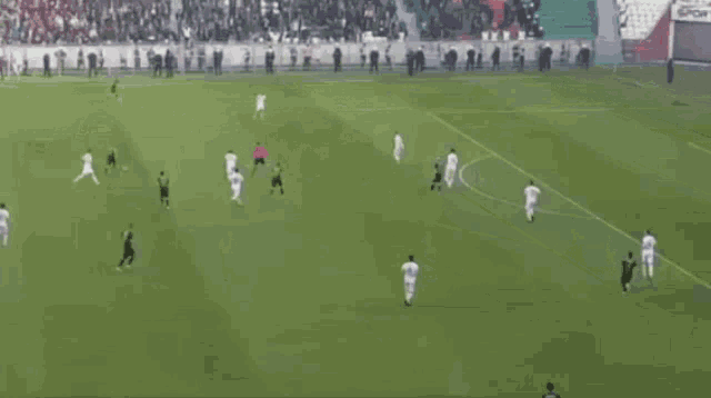 a soccer game is being played in a stadium with empty bleachers