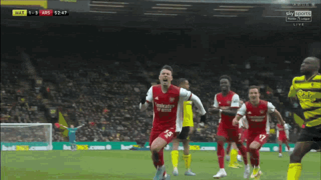 a soccer player in a red emirates fly better jersey celebrates