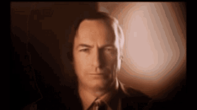 a man in a suit and tie looks at the camera