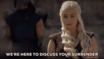 a woman with long blonde hair is standing in front of a man and says we 're here to discuss your surrender .