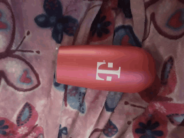a pink t-mobile bottle is laying on a pink blanket