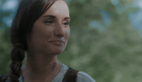 a close up of a woman 's face with a braid .