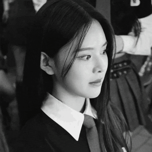 a black and white photo of a girl wearing a white collar and tie