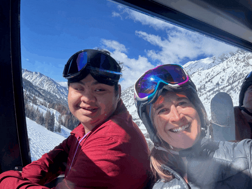 a man and a woman wearing ski goggles are looking out a window