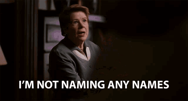 a woman behind a desk with the words i 'm not naming any names