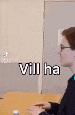 a person is sitting at a table with a bottle of pills in front of them and the words vill ha written on the screen .