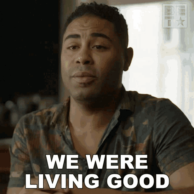 a man in a camouflage shirt says we were living good in white letters