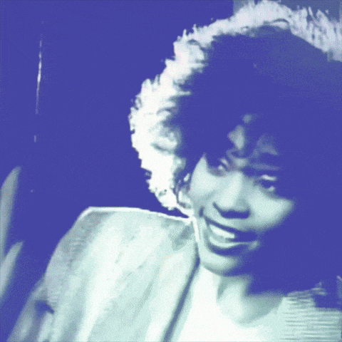 a blue and white photo of a woman with curly hair smiling
