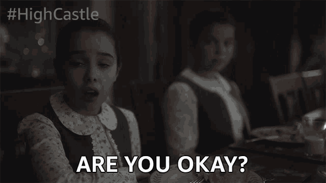 a girl sitting at a table with the words are you okay on her face